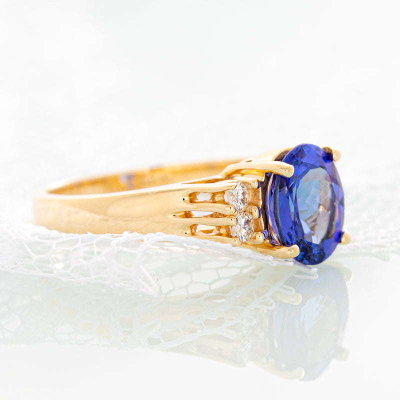 Blue Oval Tanzanite ring with diamonds in 14k yellow gold.